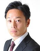 スーツの男性尾澤氏